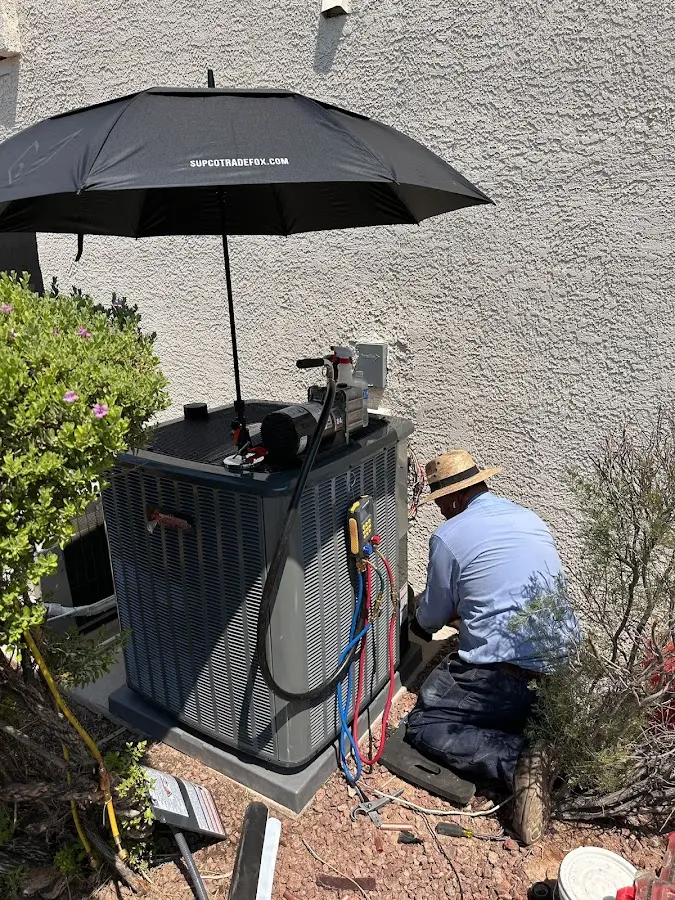 HVAC technician performing outdoor AC maintenance in Muskegon